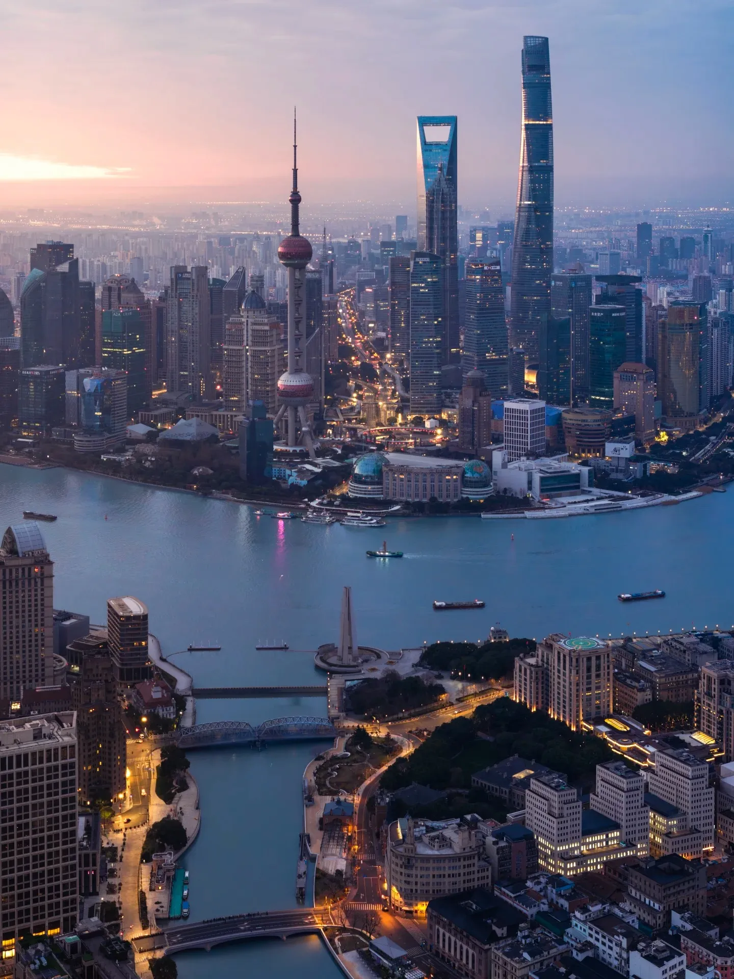 Lujiazui's towers and the Bund at dusk, seen from above Suzhou Creek.